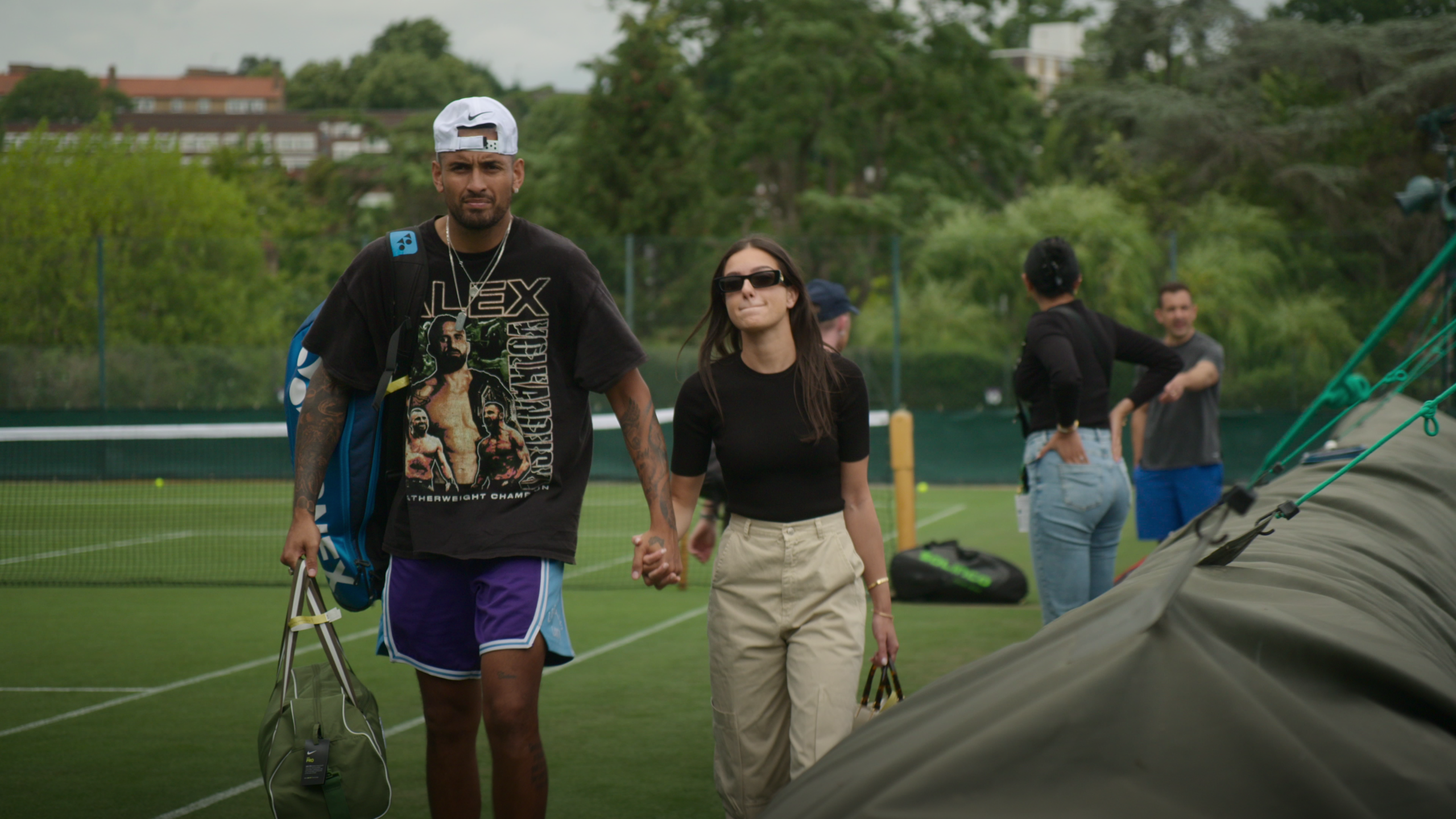 ガールフレンドと手をつなぎ練習コートを移動するキリオス（左端）　COURTESY of Netflix